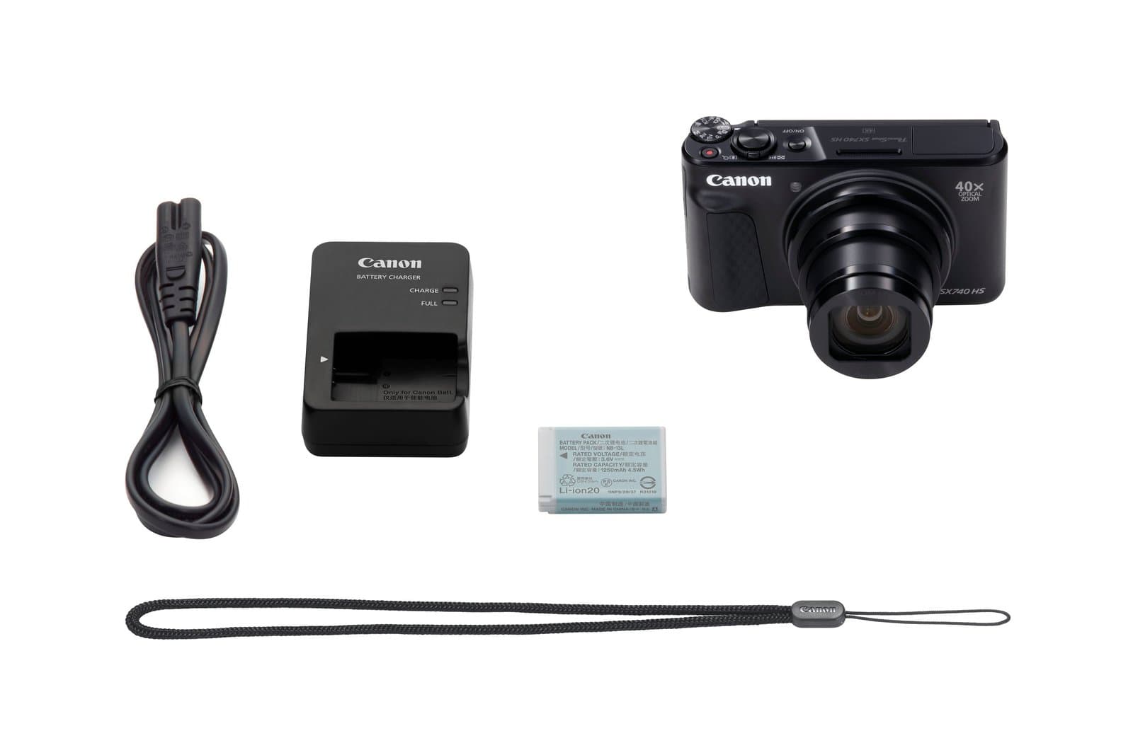 Canon PowerShot SX740 HS in black laid out with its AC cable, battery charger, battery pack and wrist strap